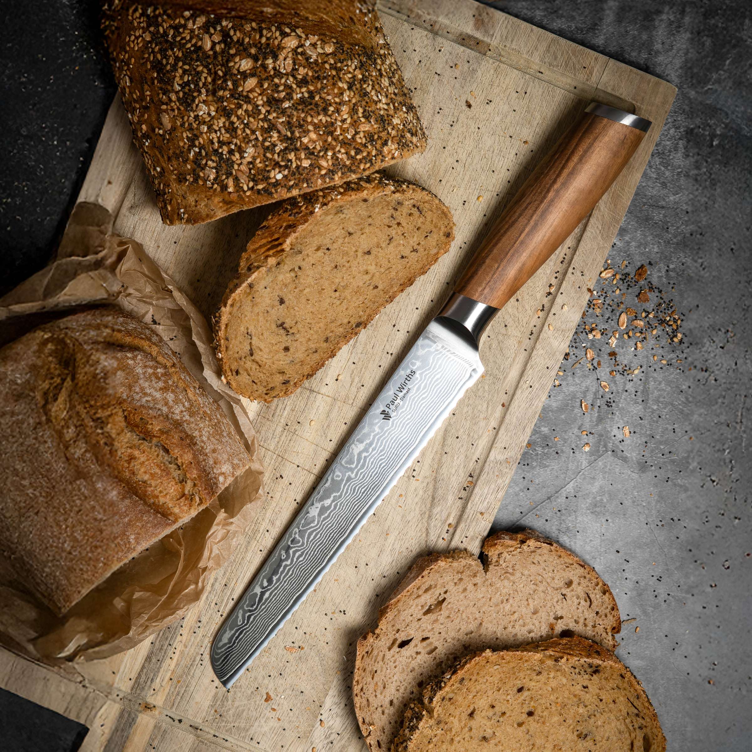 SURU Brotmesser von Paul Wirths, scharfes Küchenmesser mit Wellenschliff, liegt auf Holzbrett, ideal zum Schneiden von Brot.