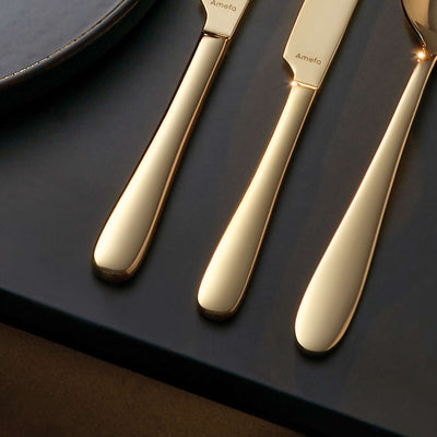 Amefa Oxford Besteckset 24-teilig in Champagner PVD, Besteck mit Messer, Gabel, Löffel auf dunklem Hintergrund sichtbar