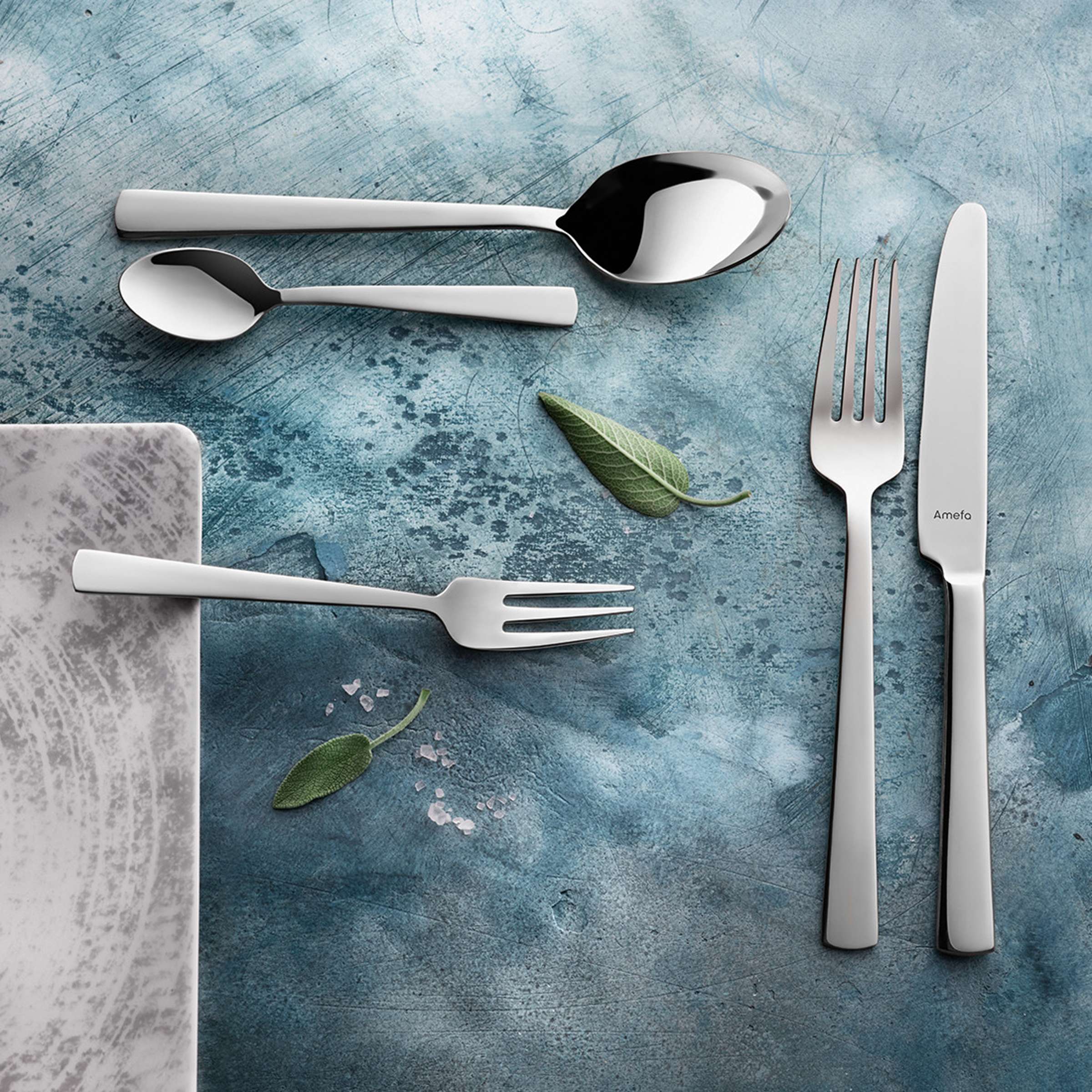 Modernes Amefa Besteckset, 24-teilig, Edelstahl, Messer, Gabeln, Löffel, elegantes Design auf weißem Hintergrund