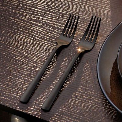 Amefa Ventura Besteckset 24-teilig aus PVD-schwarz mattiertem Edelstahl, Messer, Gabeln und Löffel auf dunklem Hintergrund