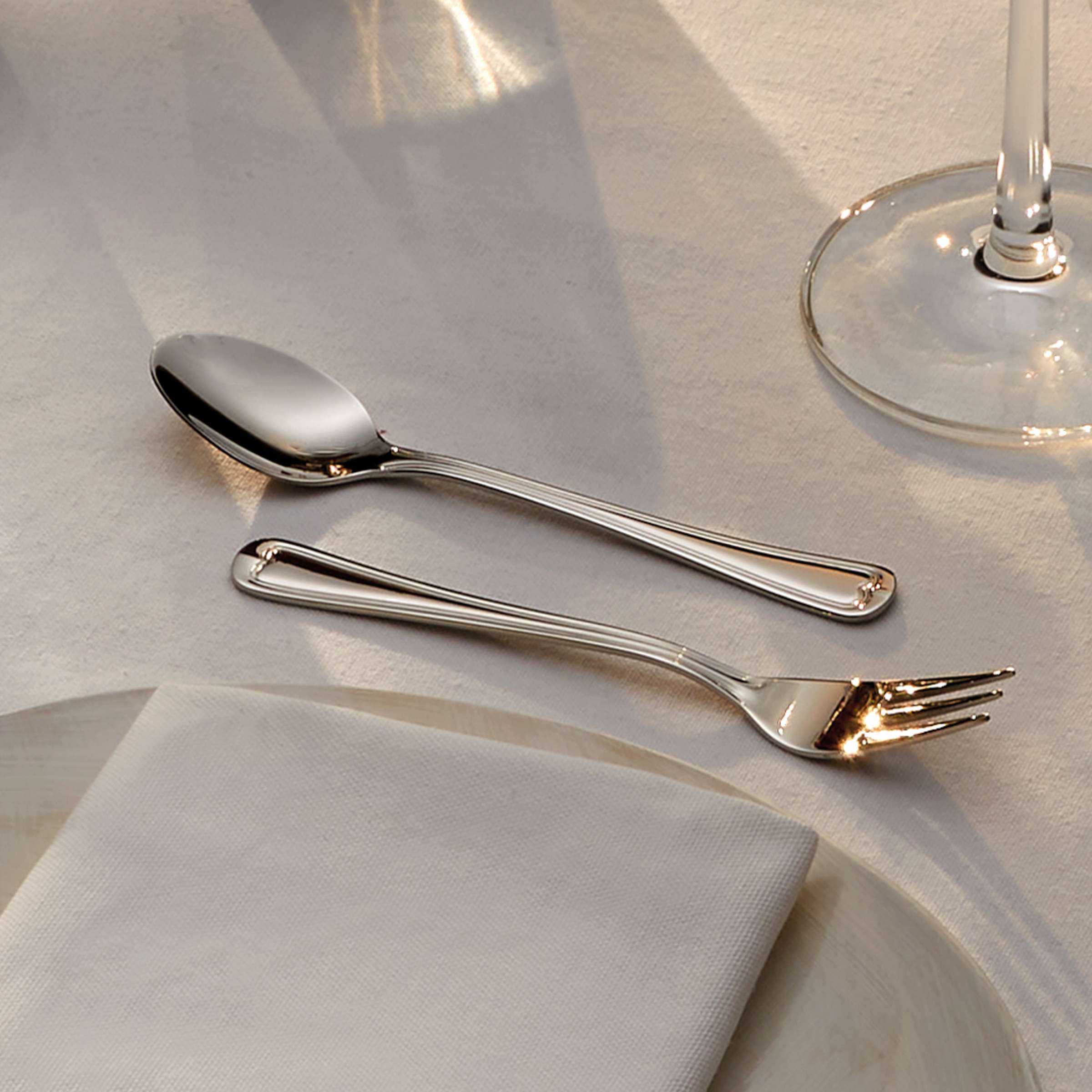 ELEGANCE Besteckset 24-teilig von Amefa mit Messer, Gabel, Löffel aus Edelstahl, elegant auf dunklem Hintergrund präsentiert.