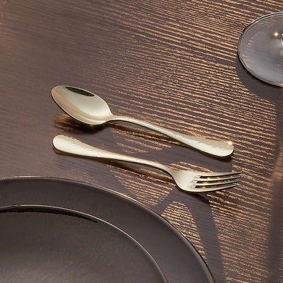 Amefa Sierra Besteckset 30-teilig aus PVD-Champagner mit Messer, Gabel, Löffel und Teelöffel auf dunklem Hintergrund.