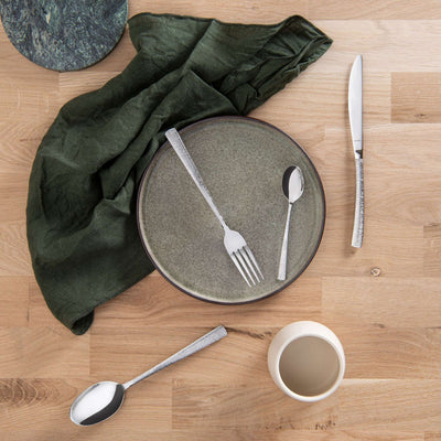 HAVANE Besteckset 24-teilig von Amefa, Edelstahl, bestehend aus Gabeln, Messern, Löffeln auf einem gedeckten Tisch.