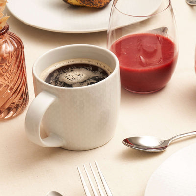 Weiße IZY-Tasse von Médard de Noblat, elegante Tasse aus Geschirrserie, perfekt für Kaffee oder Tee, auf weißem Hintergrund.